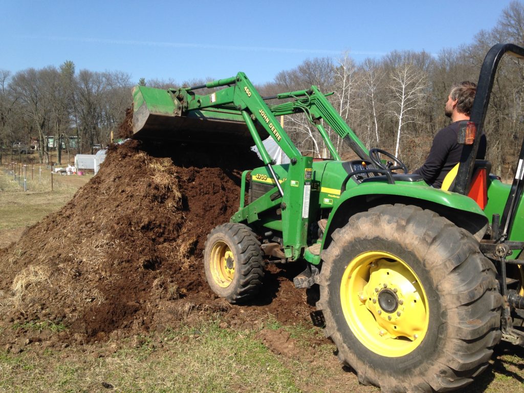 turning the pile of old horse manure with Neighbor Dave's tractor